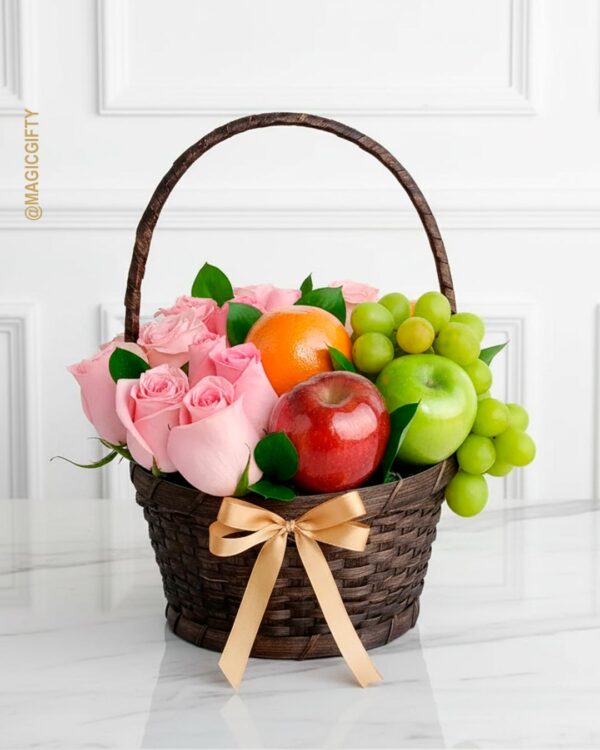 Eden Rose — canasta de mimbre con rosas rosadas, manzanas, naranja y uvas verdes
