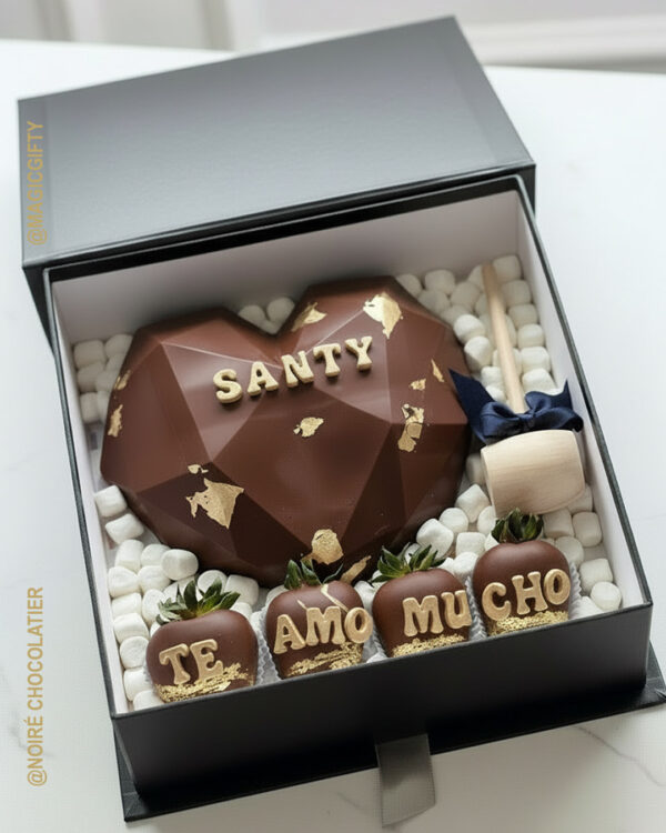 Caja tipo libro negra con corazón diamante de chocolate oscuro con detalles dorados, fresas personalizadas con mensaje y martillo de madera