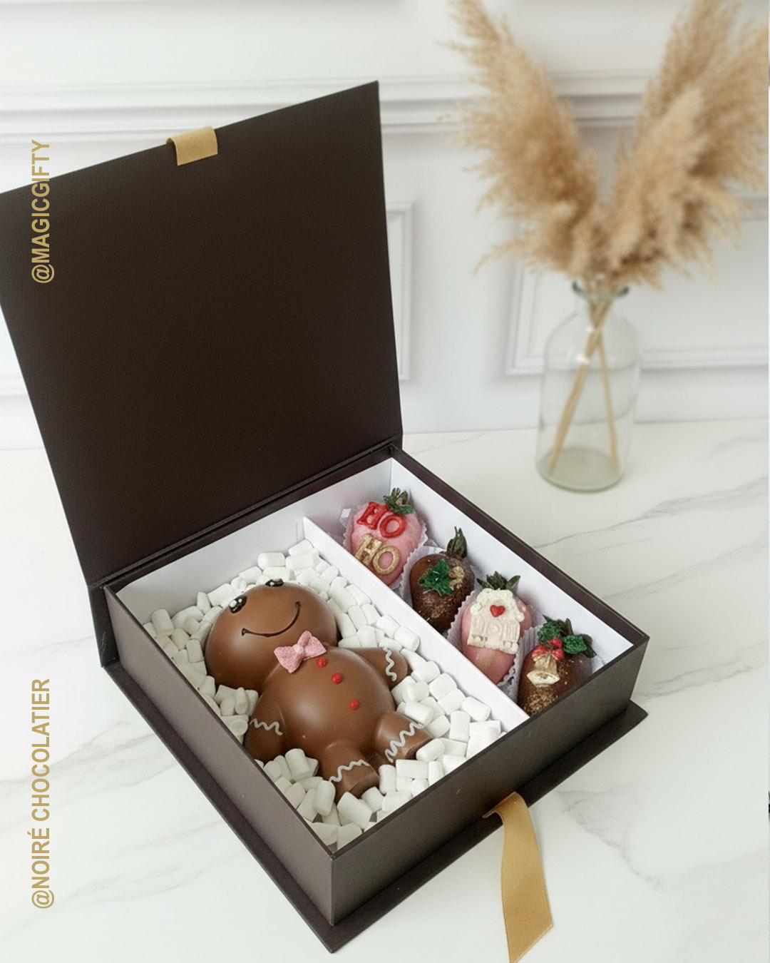 Caja tipo libro negra con figura de chocolate temática galleta y fresas navideñas decoradas, presentación premium para regalo