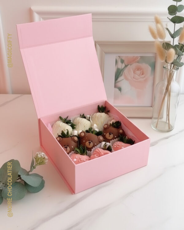 Caja rosa tipo libro con fresas premium decoradas como ositos y fresas cubiertas en chocolate, presentación tierna lista para regalo