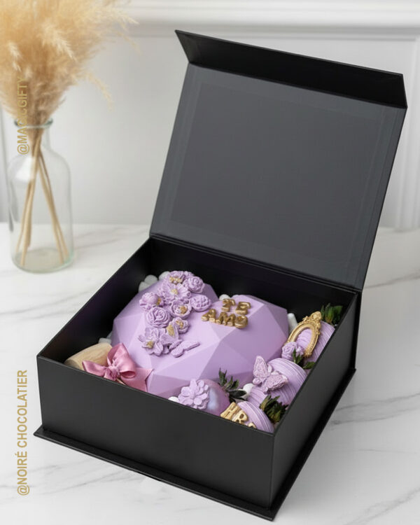 Caja tipo libro negra con corazón diamante de chocolate color lila, fresas personalizadas decoradas y detalles premium para regalo