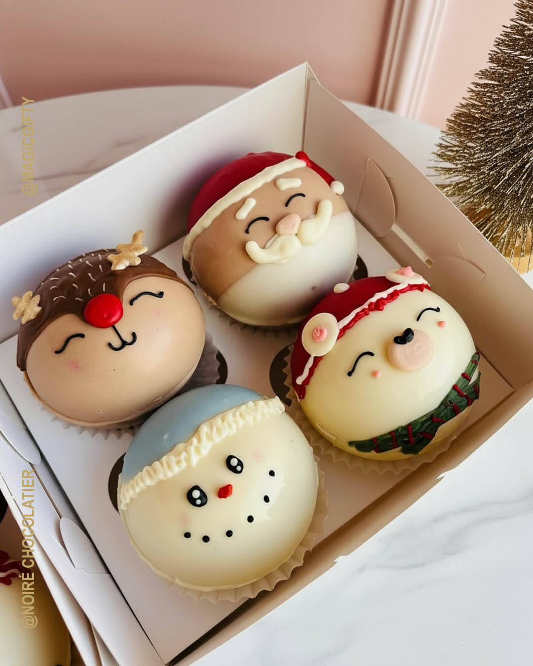 Caja con chocobombs personajes navideños decorados a mano: reno, santa, muñeco de nieve y personaje navideño, sobre fondo blanco